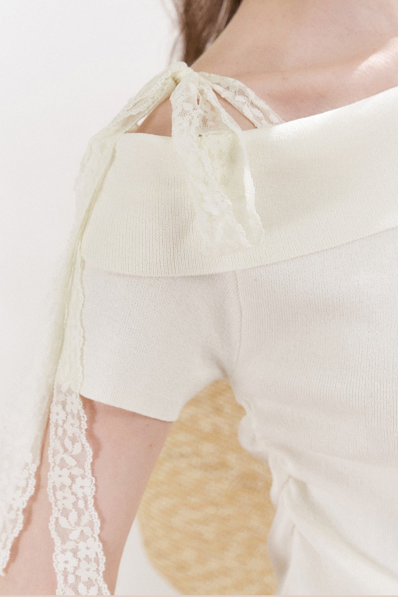 Top in maglia con spalle scoperte e fiocco in pizzo