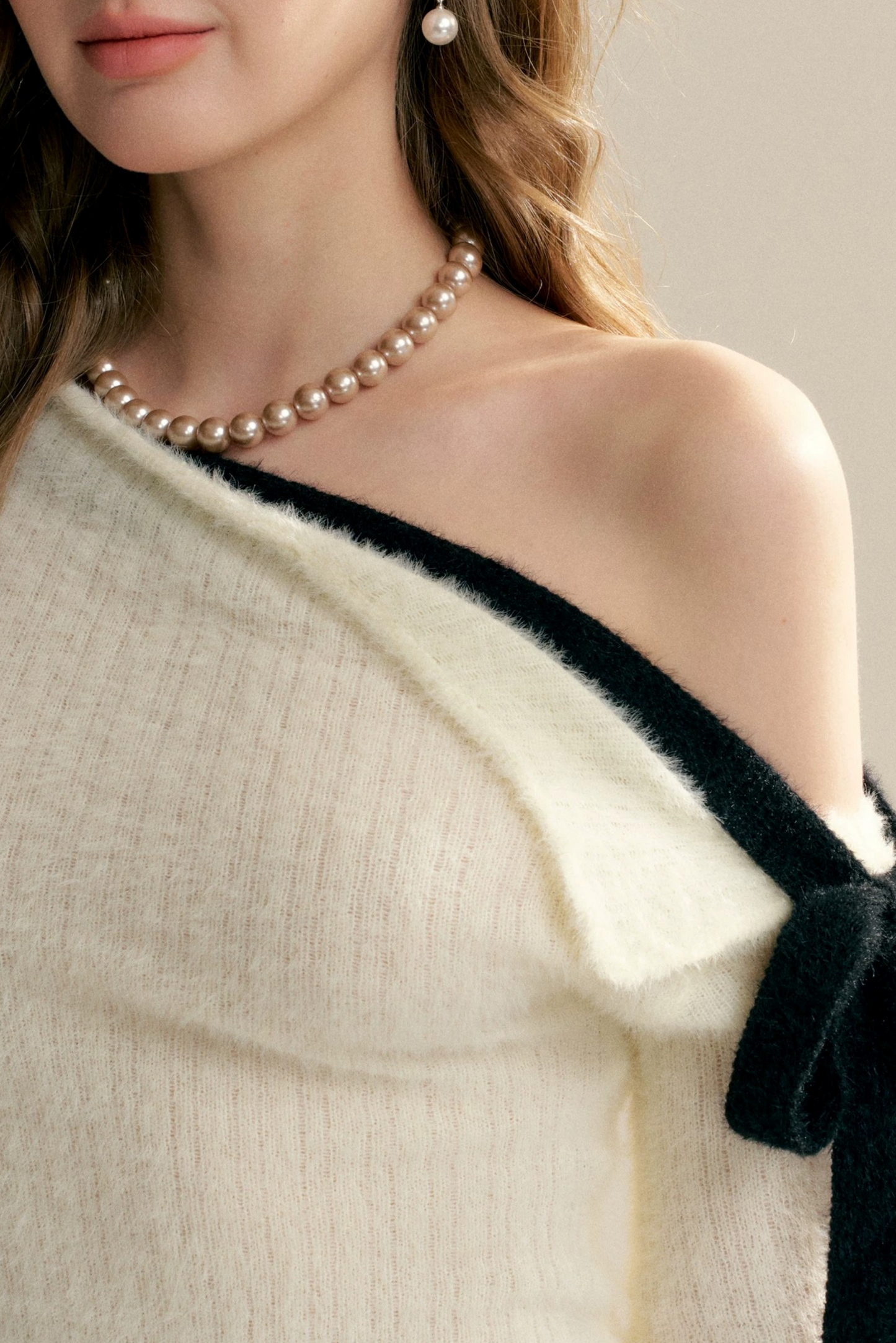 Pull épaules dénudées avec nœud asymétrique