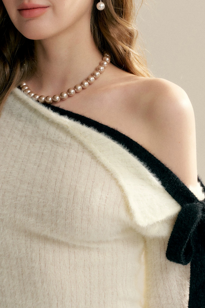 Pull épaules dénudées avec nœud asymétrique
