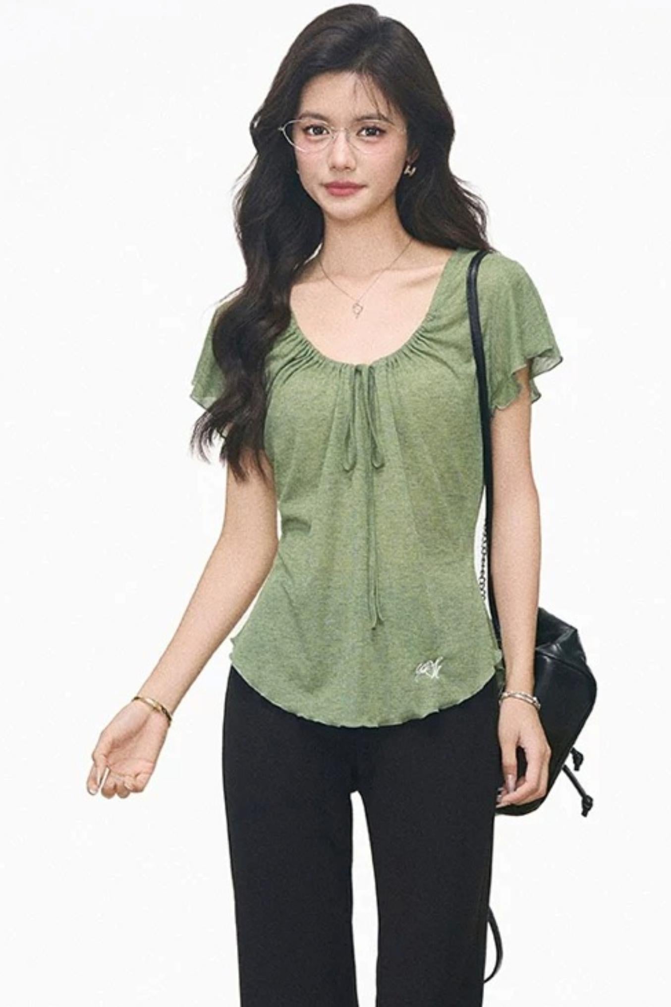 Completo con maglia verde con coulisse e pantaloni neri svasati