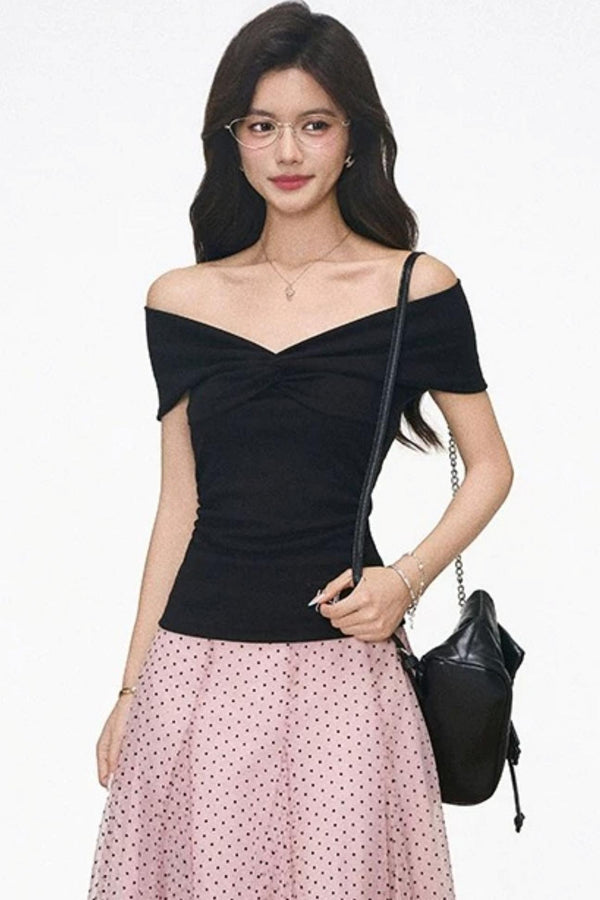 Conjunto de top negro de punto con hombros descubiertos y falda rosa