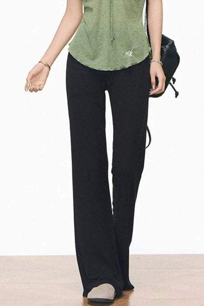 Completo con maglia verde con coulisse e pantaloni neri svasati