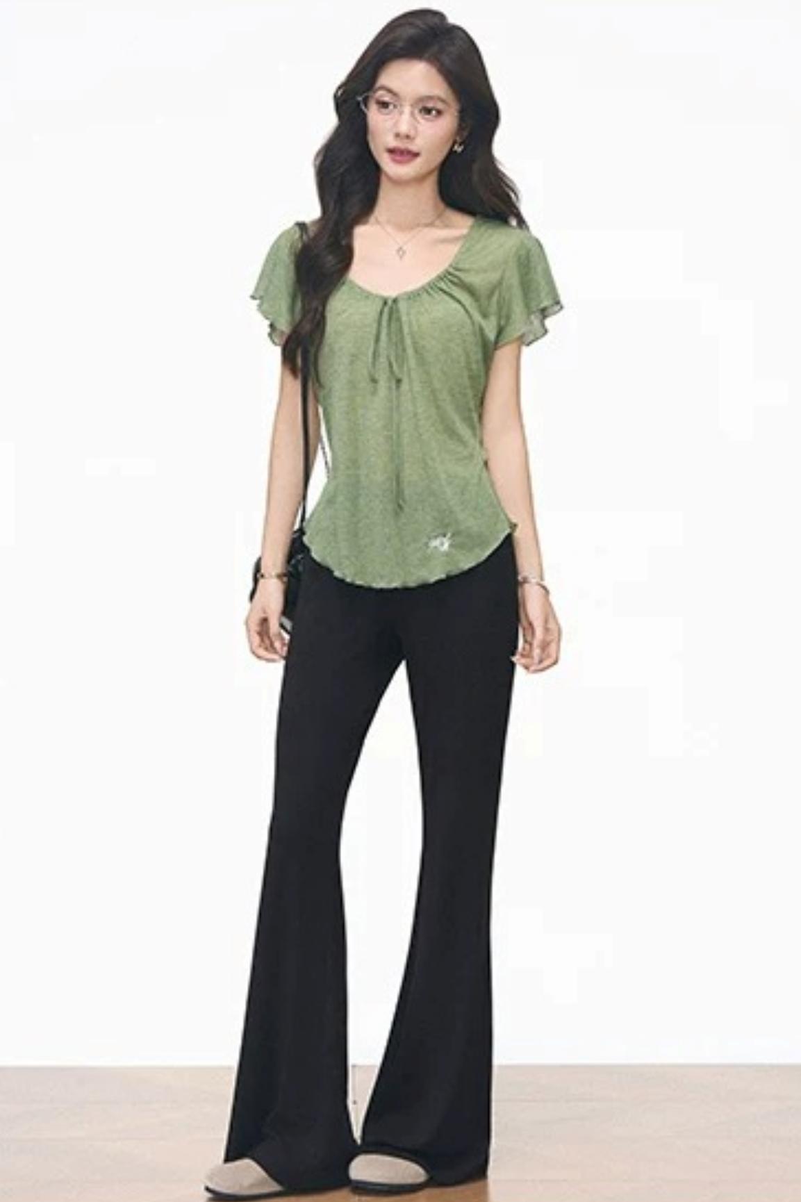 Completo con maglia verde con coulisse e pantaloni neri svasati