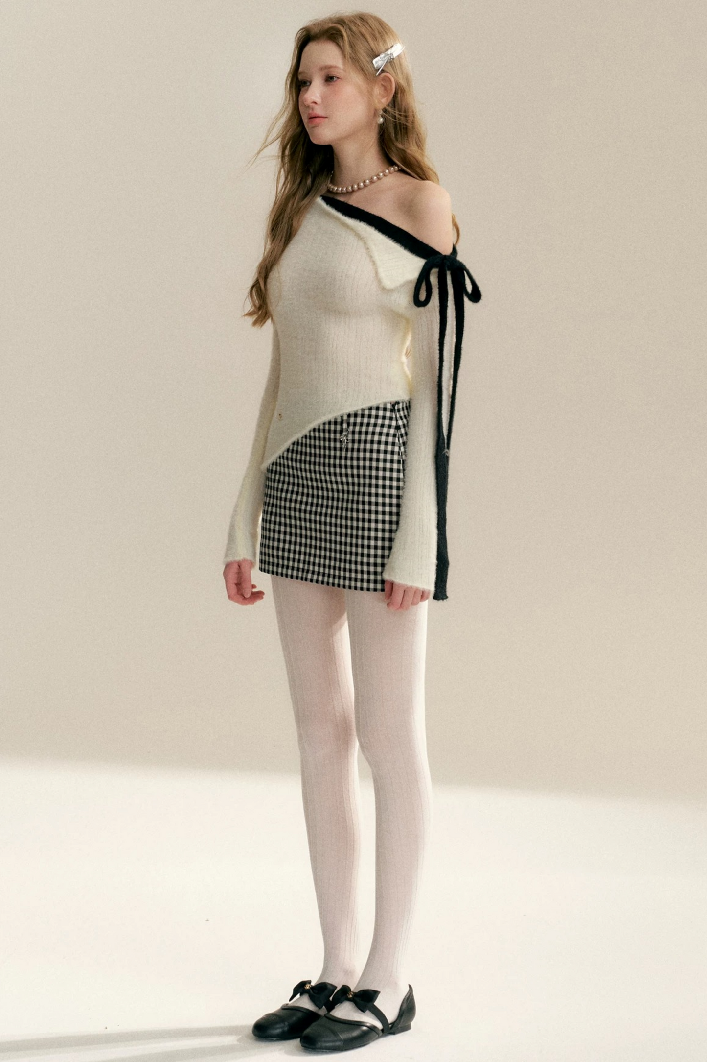 Pull épaules dénudées avec nœud asymétrique