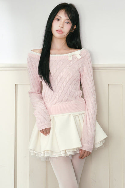 Pull en maille torsadée rose à nœud