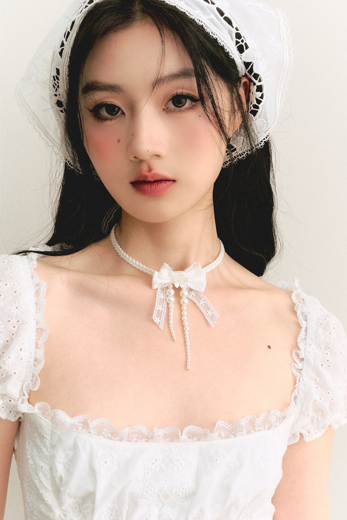 Weiße Choker-Halskette mit Spitzenschleife und Perlenband