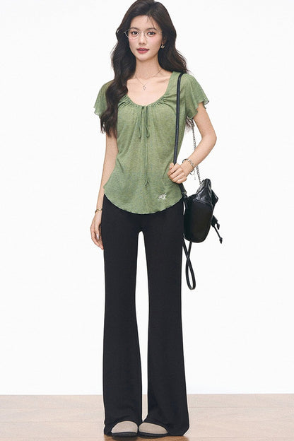 Completo con maglia verde con coulisse e pantaloni neri svasati