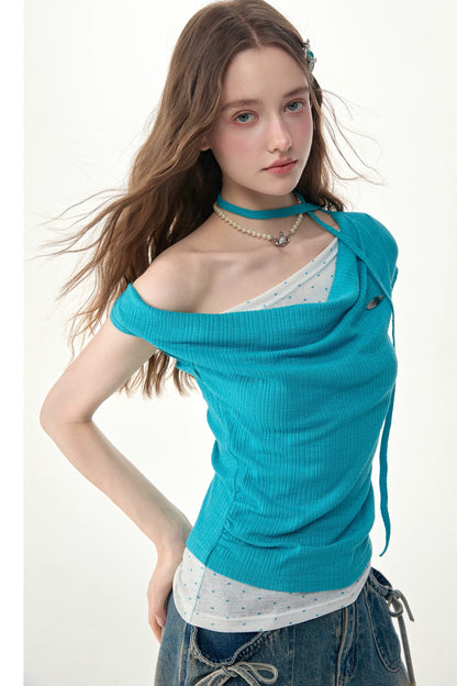 Top in maglia blu a pois con collo drappeggiato asimmetrico