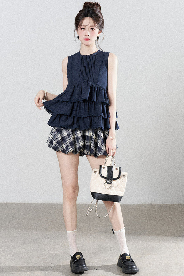 Conjunto de camisa azul marino con volantes y falda de cuadros
