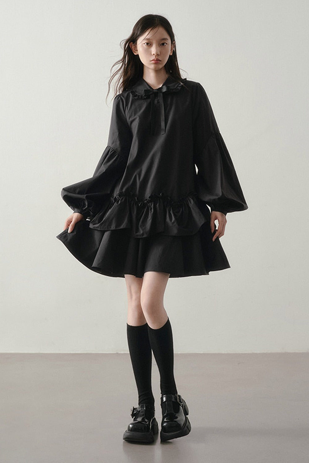Robe noire asymétrique à volants et manches lanternes