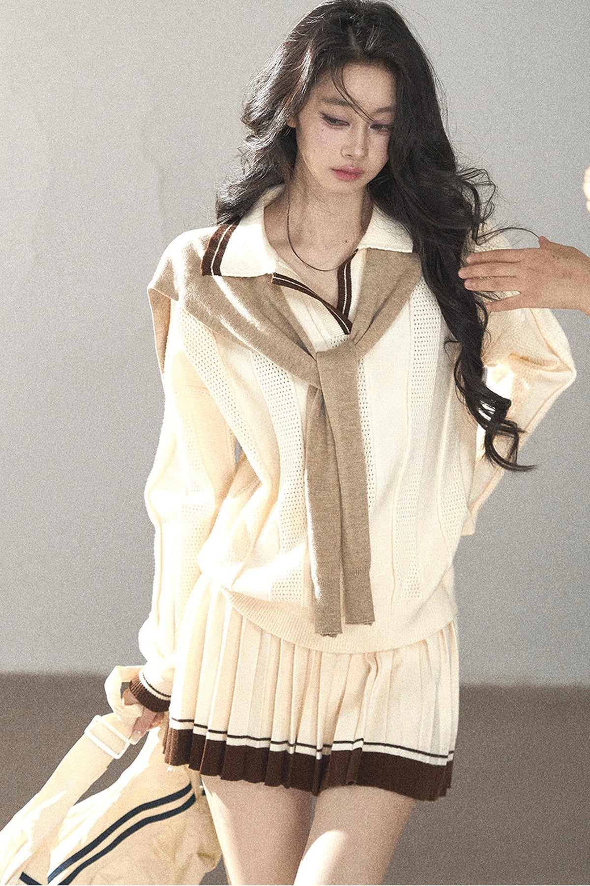Completo con top a maglia, gonna corta plissettata e giacca
