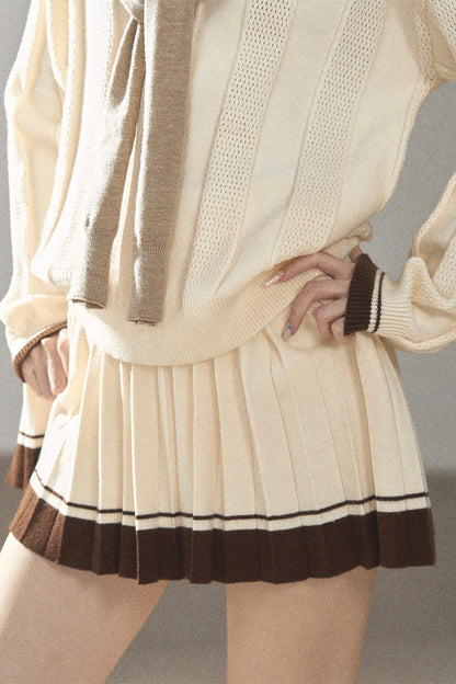 Completo con top a maglia, gonna corta plissettata e giacca