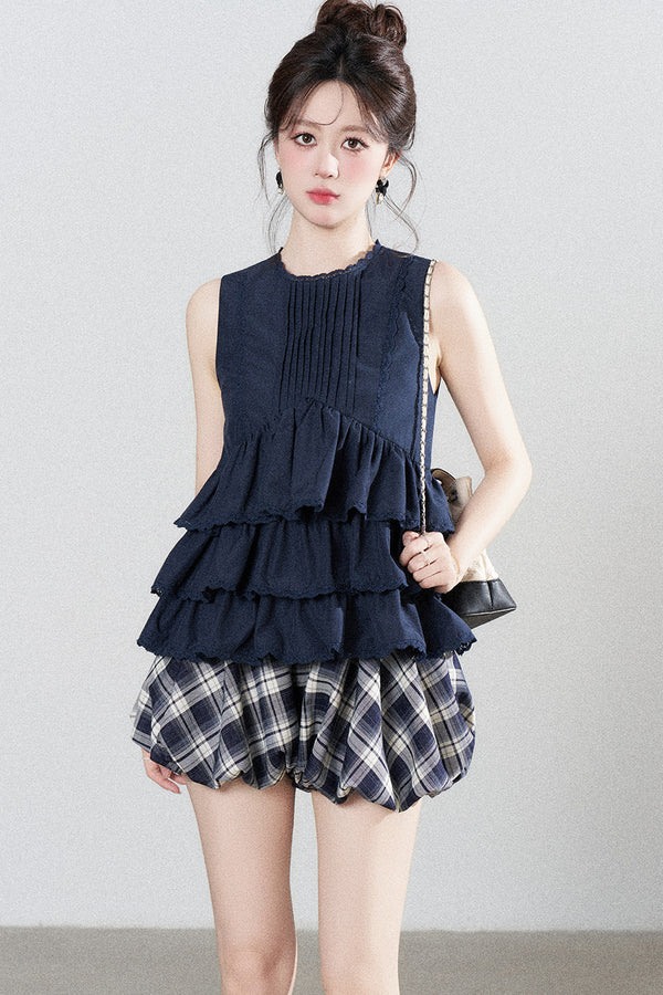 Conjunto de camisa azul marino con volantes y falda de cuadros