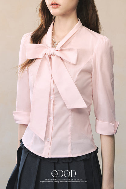 Camisa rosa de manga larga con lazada al cuello y mariposa