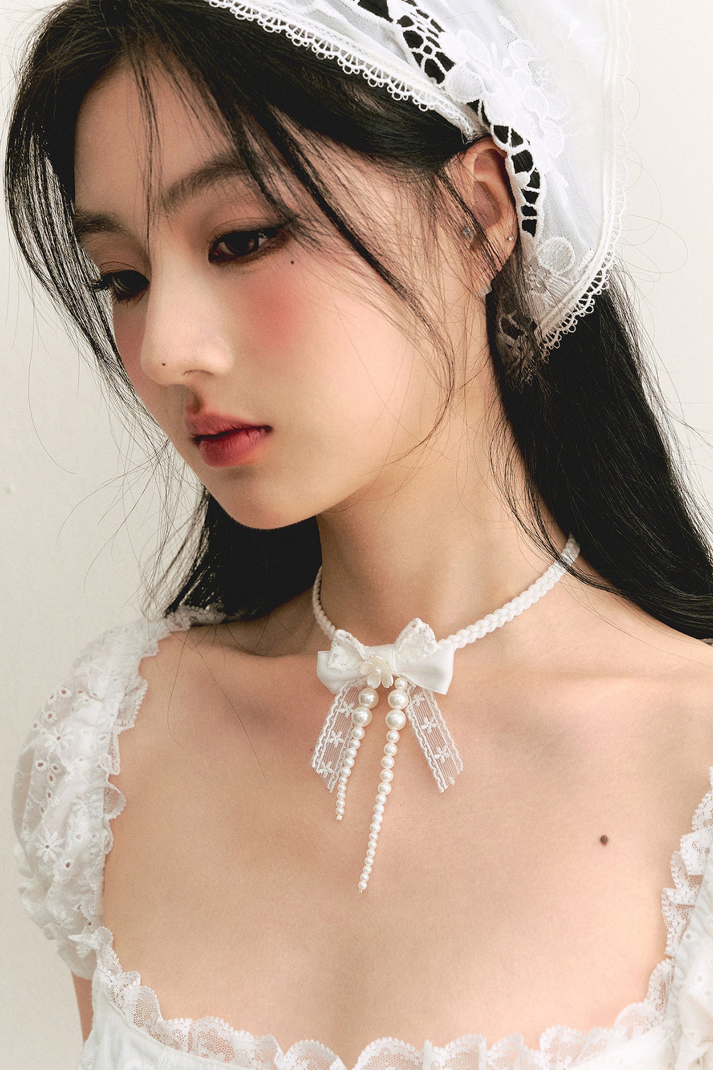 Weiße Choker-Halskette mit Spitzenschleife und Perlenband