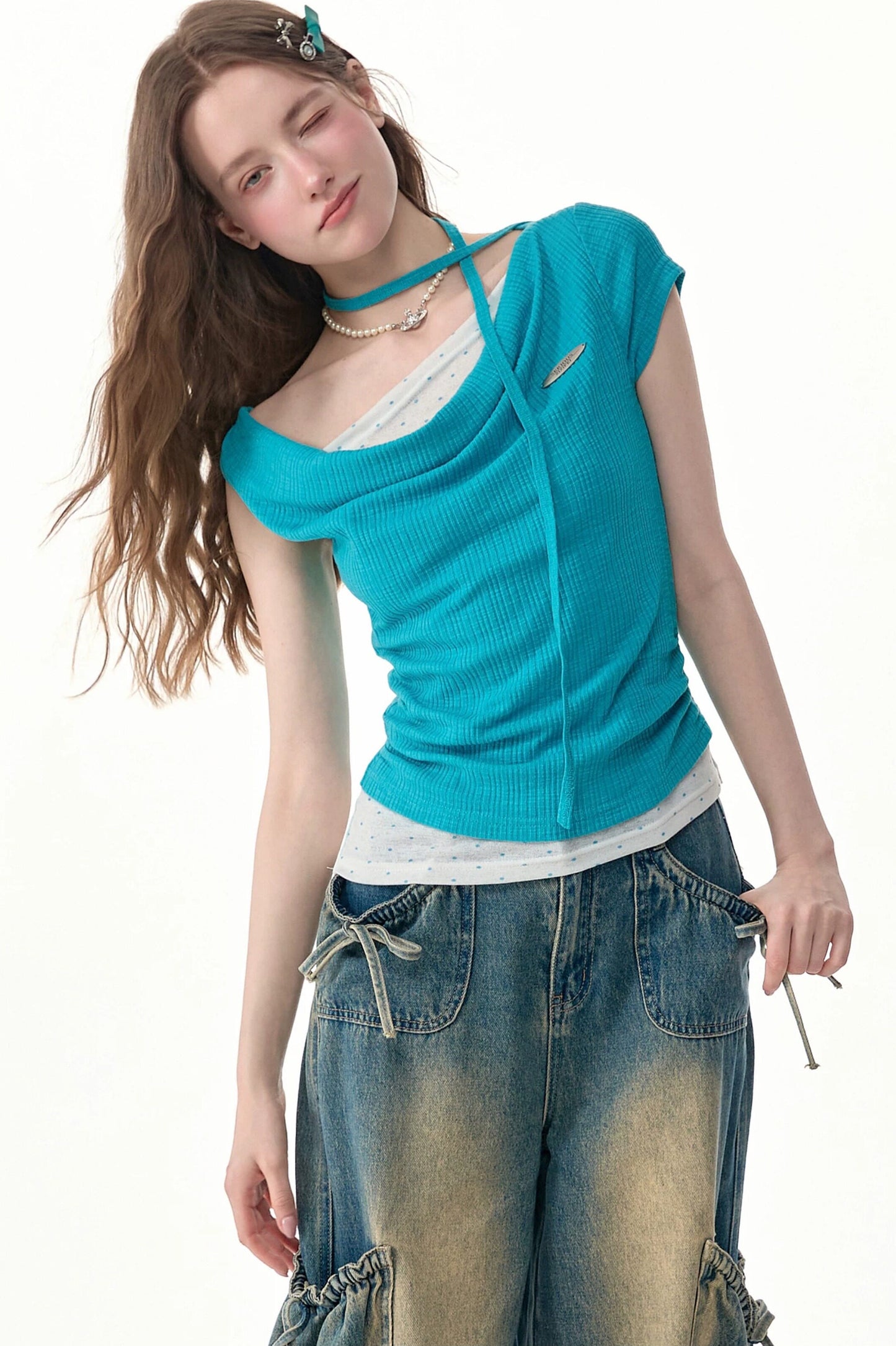 Top in maglia blu a pois con collo drappeggiato asimmetrico