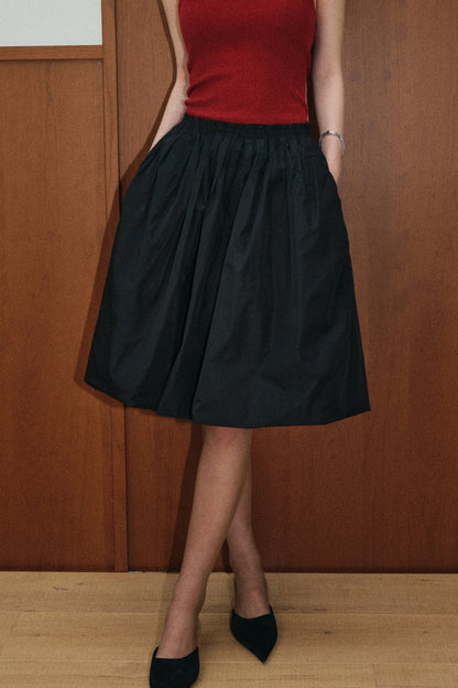 Set aus roter Strickjacke und schwarzem Rock