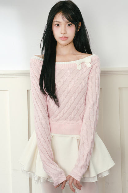 Pull en maille torsadée rose à nœud