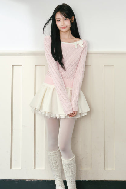 Pull en maille torsadée rose à nœud