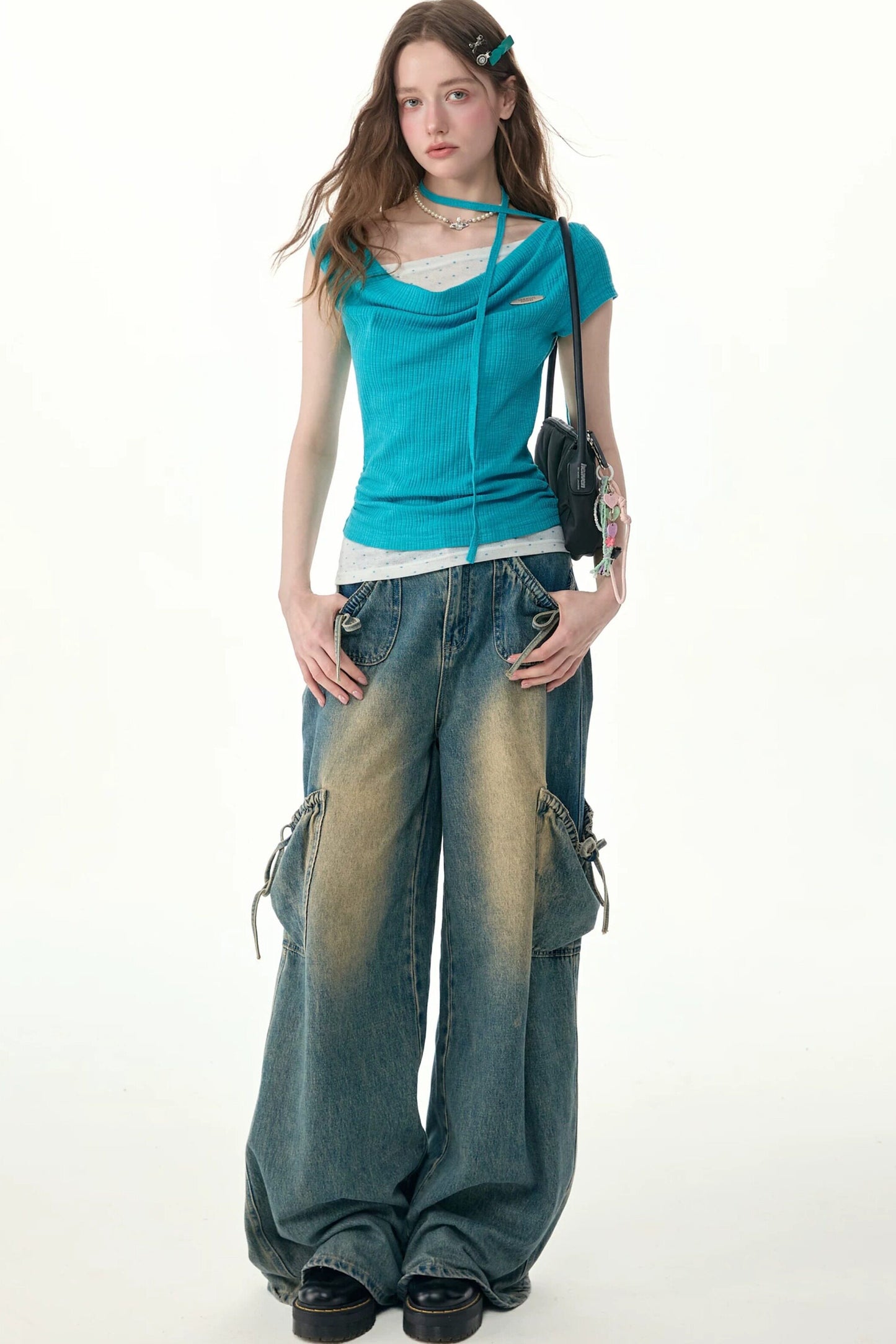 Top in maglia blu a pois con collo drappeggiato asimmetrico
