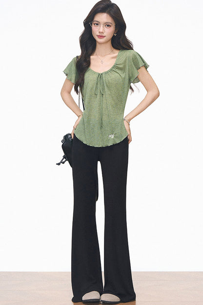 Completo con maglia verde con coulisse e pantaloni neri svasati