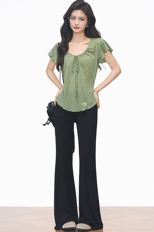 Completo con maglia verde con coulisse e pantaloni neri svasati