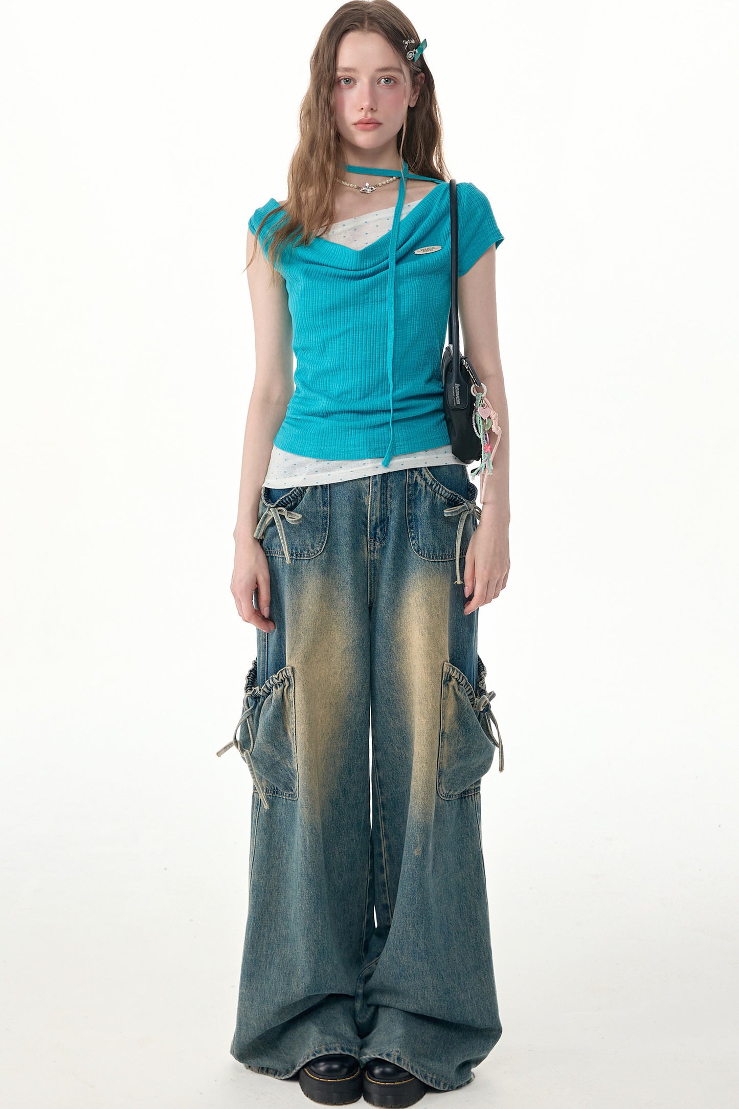 Top in maglia blu a pois con collo drappeggiato asimmetrico