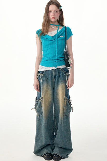 Top in maglia blu a pois con collo drappeggiato asimmetrico