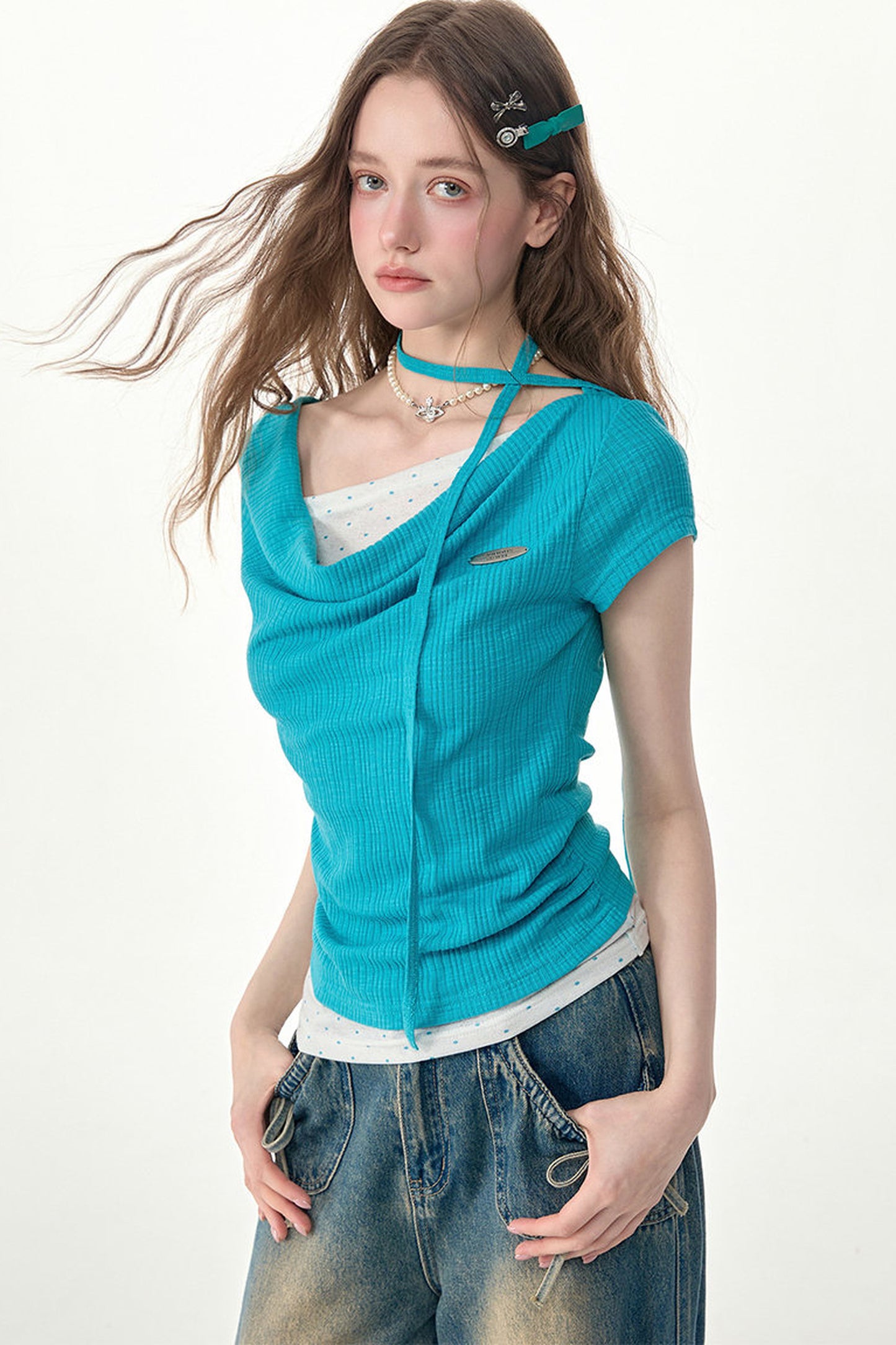 Top in maglia blu a pois con collo drappeggiato asimmetrico