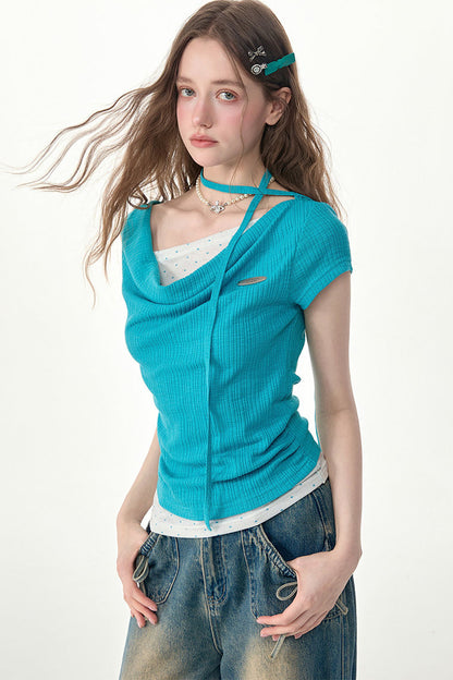 Top in maglia blu a pois con collo drappeggiato asimmetrico