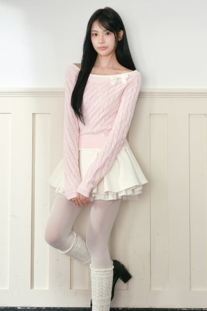 Pull en maille torsadée rose à nœud