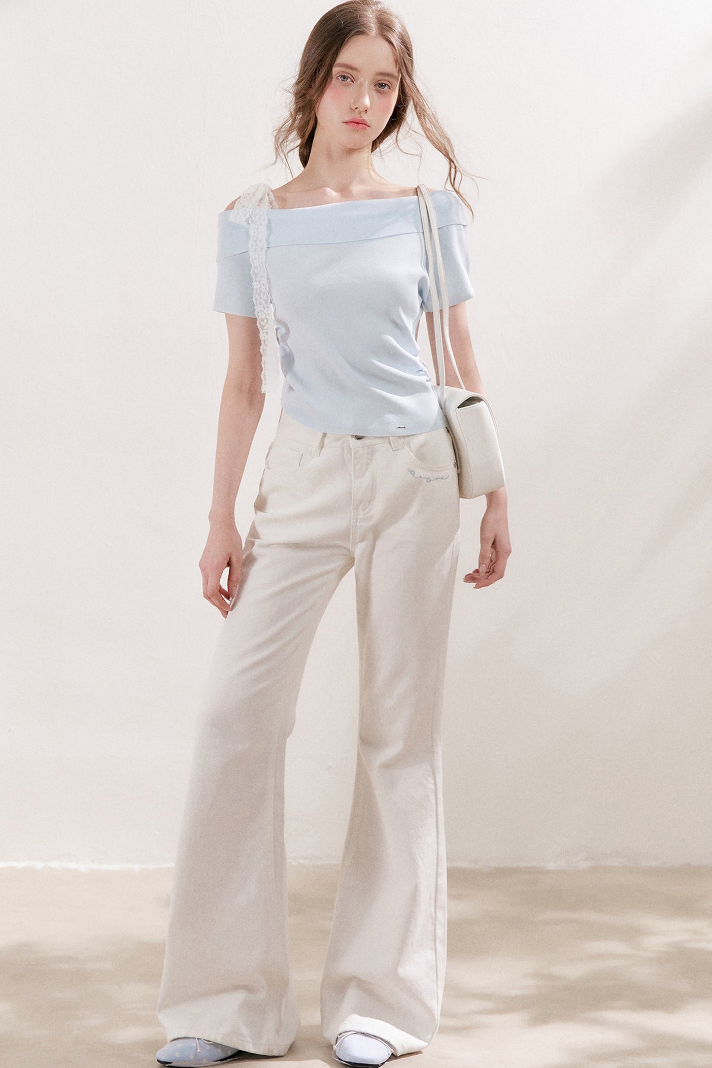 Top in maglia con spalle scoperte e fiocco in pizzo