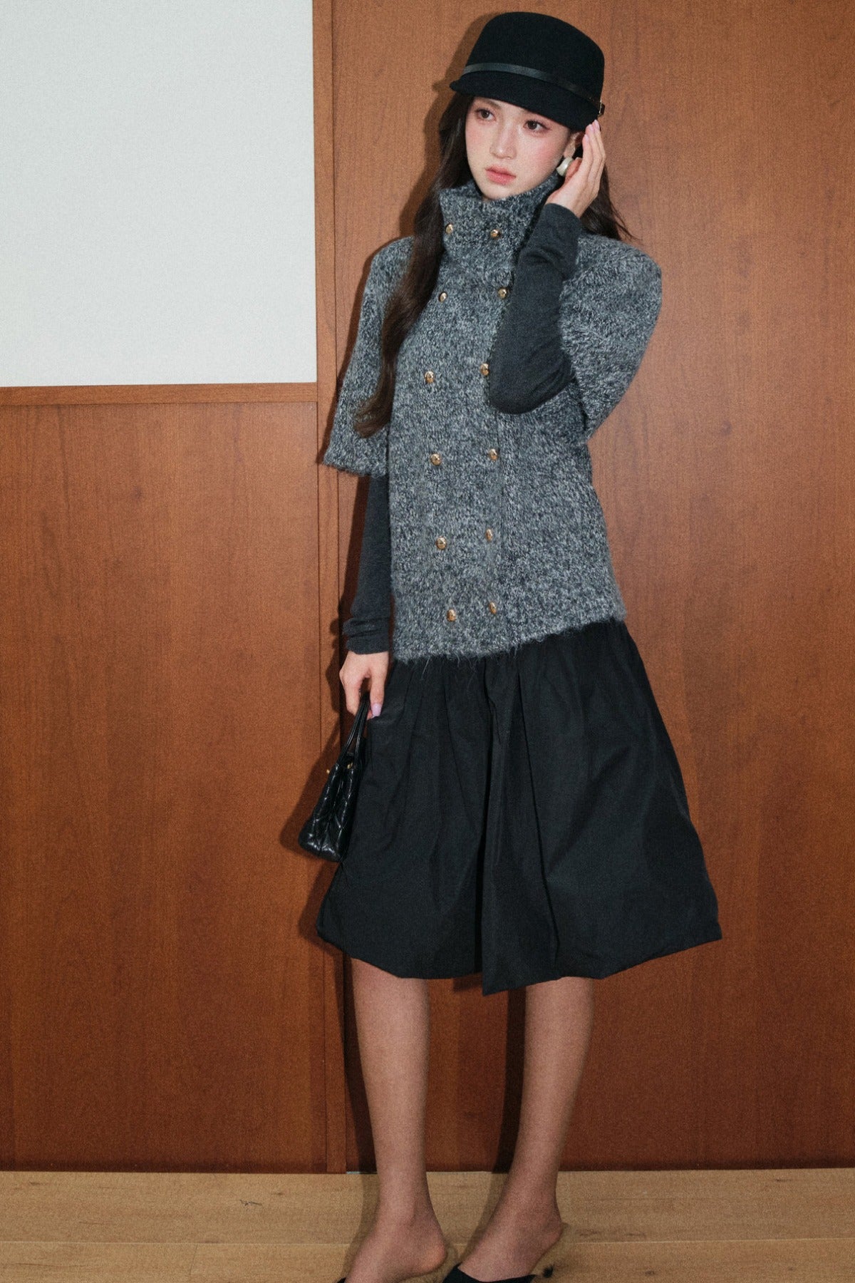 Set aus schwarz-grauem Wollpullover mit zweireihiger Knopfleiste und A-Linien-Rock
