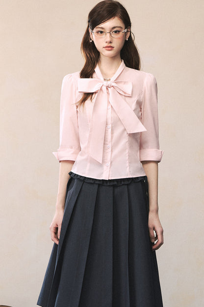 Camisa rosa de manga larga con lazada al cuello y mariposa