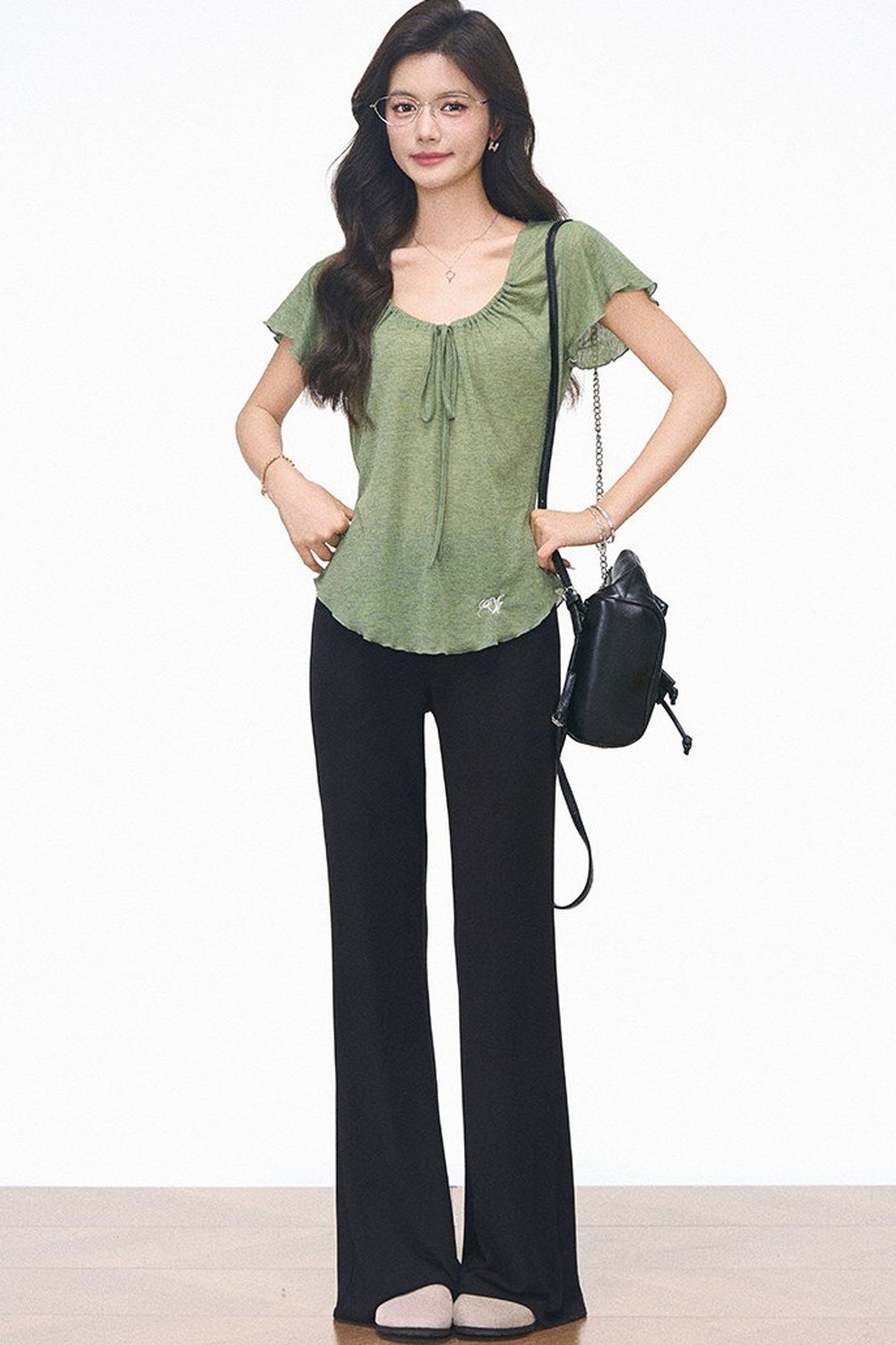 Completo con maglia verde con coulisse e pantaloni neri svasati