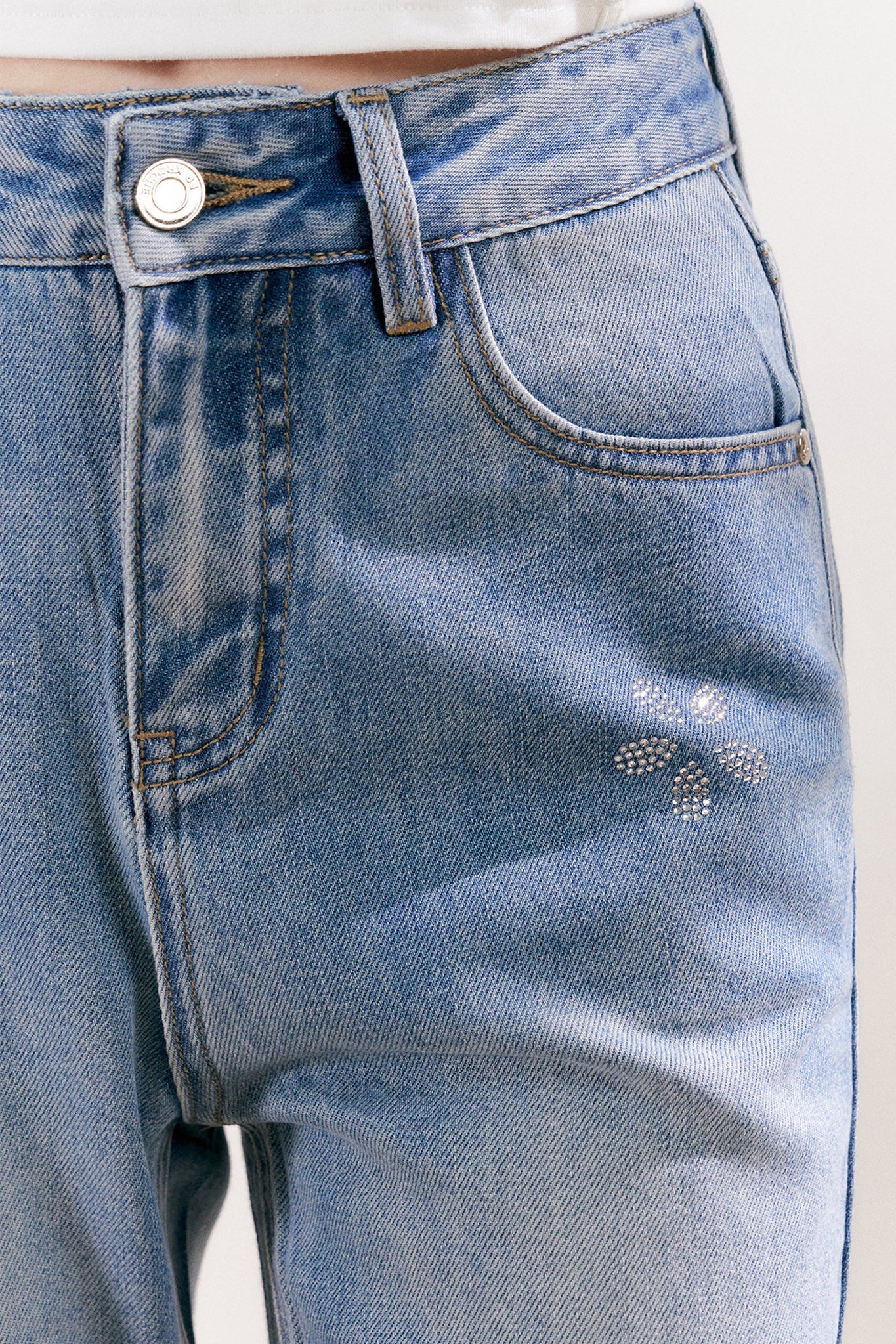Jean en denim bleu avec fleur à cinq pétales en strass