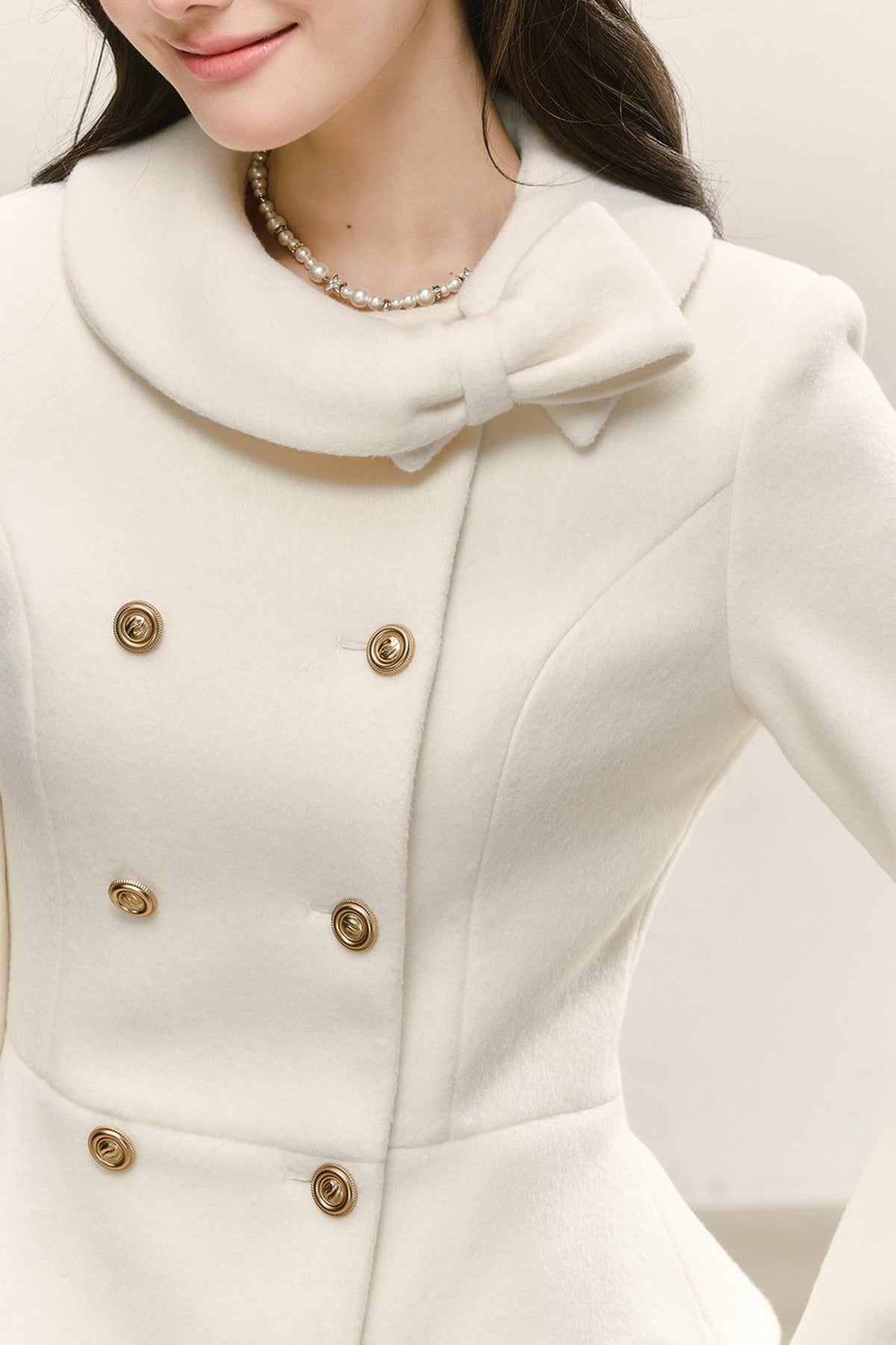 Completo con cappotto bianco doppiopetto che segna il punto vita