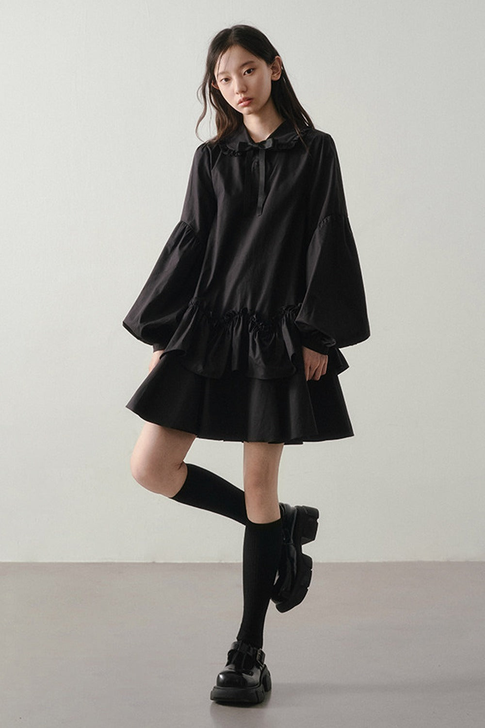 Robe noire asymétrique à volants et manches lanternes