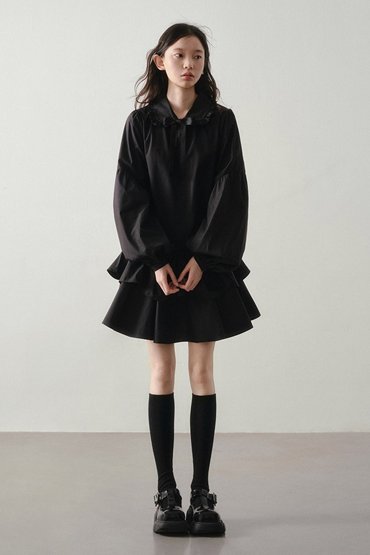 Robe noire asymétrique à volants et manches lanternes
