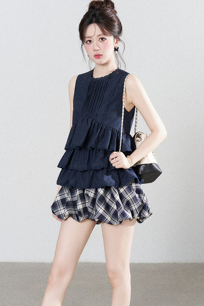 Conjunto de camisa azul marino con volantes y falda de cuadros