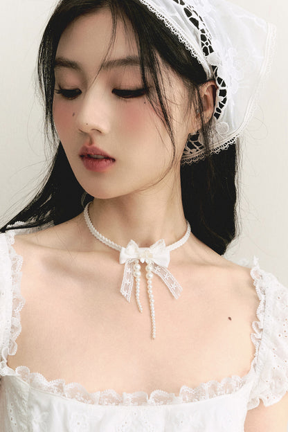 Weiße Choker-Halskette mit Spitzenschleife und Perlenband