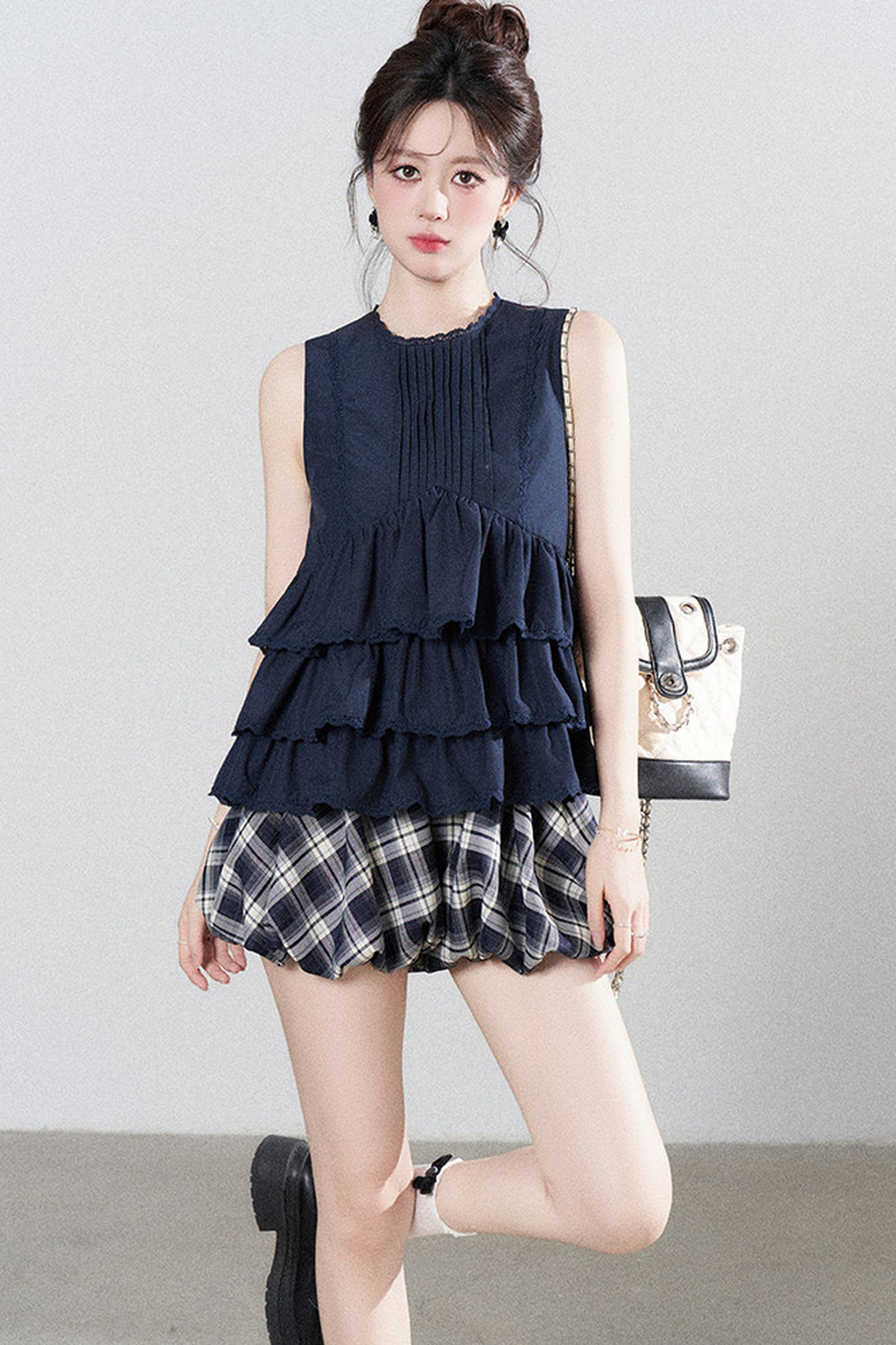Conjunto de camisa azul marino con volantes y falda de cuadros