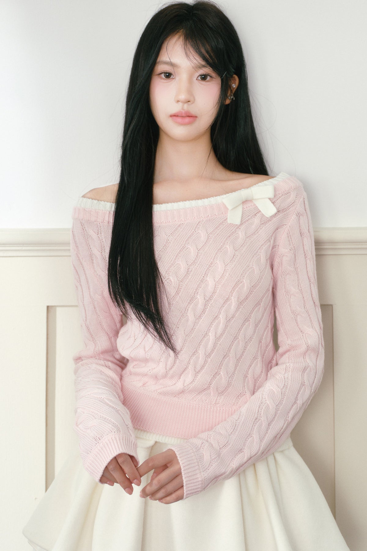 Pull en maille torsadée rose à nœud