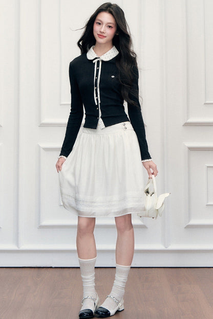 Completo con top in maglia a maniche lunghe e gonna a pois con toppe