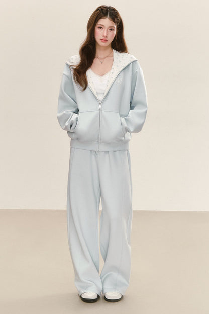 Completo con giacca con cappuccio dalla vestibilità comoda e pantaloni della tuta a gamba larga