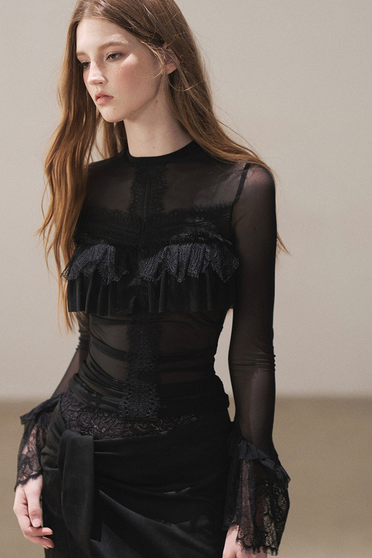 Blusa de encaje transparente con volantes y mangas acampanadas