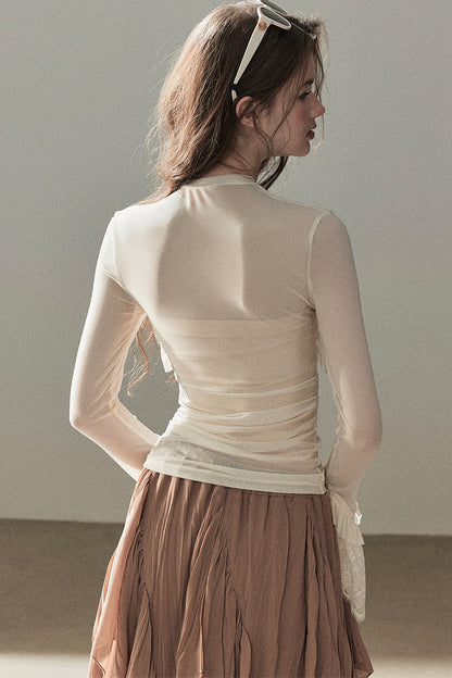 Blusa de encaje transparente con volantes y mangas acampanadas