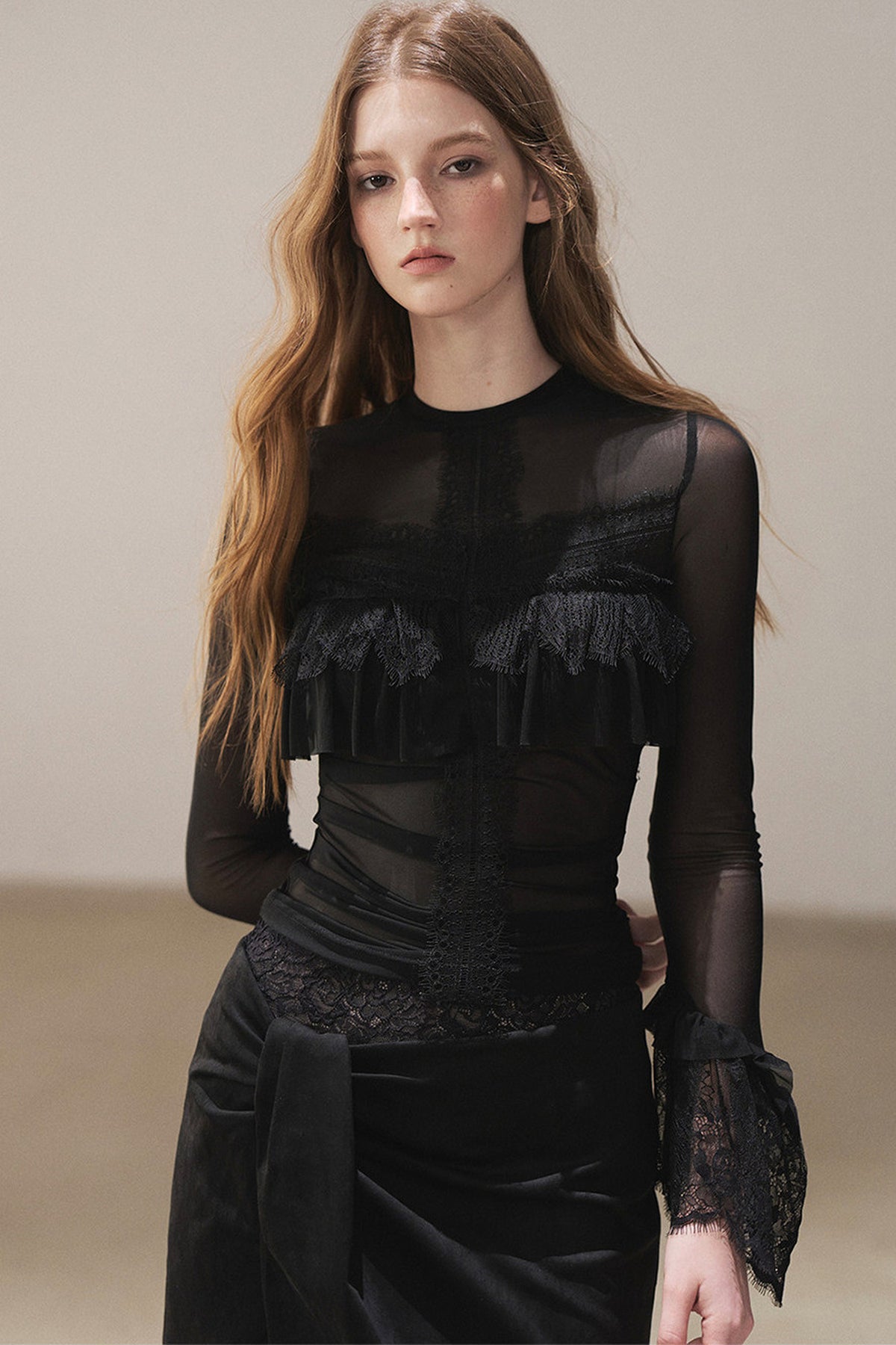 Blusa de encaje transparente con volantes y mangas acampanadas