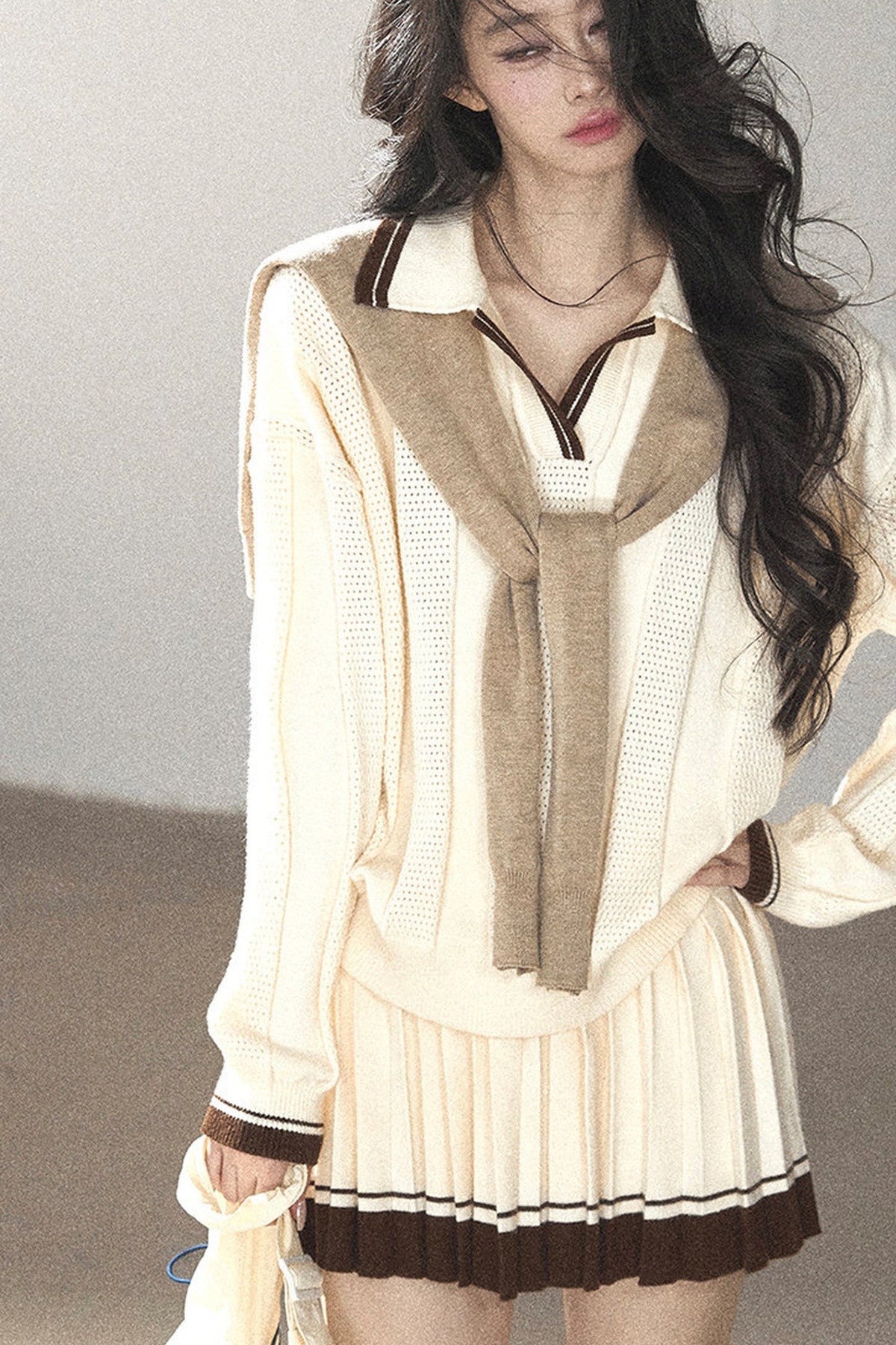 Completo con top a maglia, gonna corta plissettata e giacca