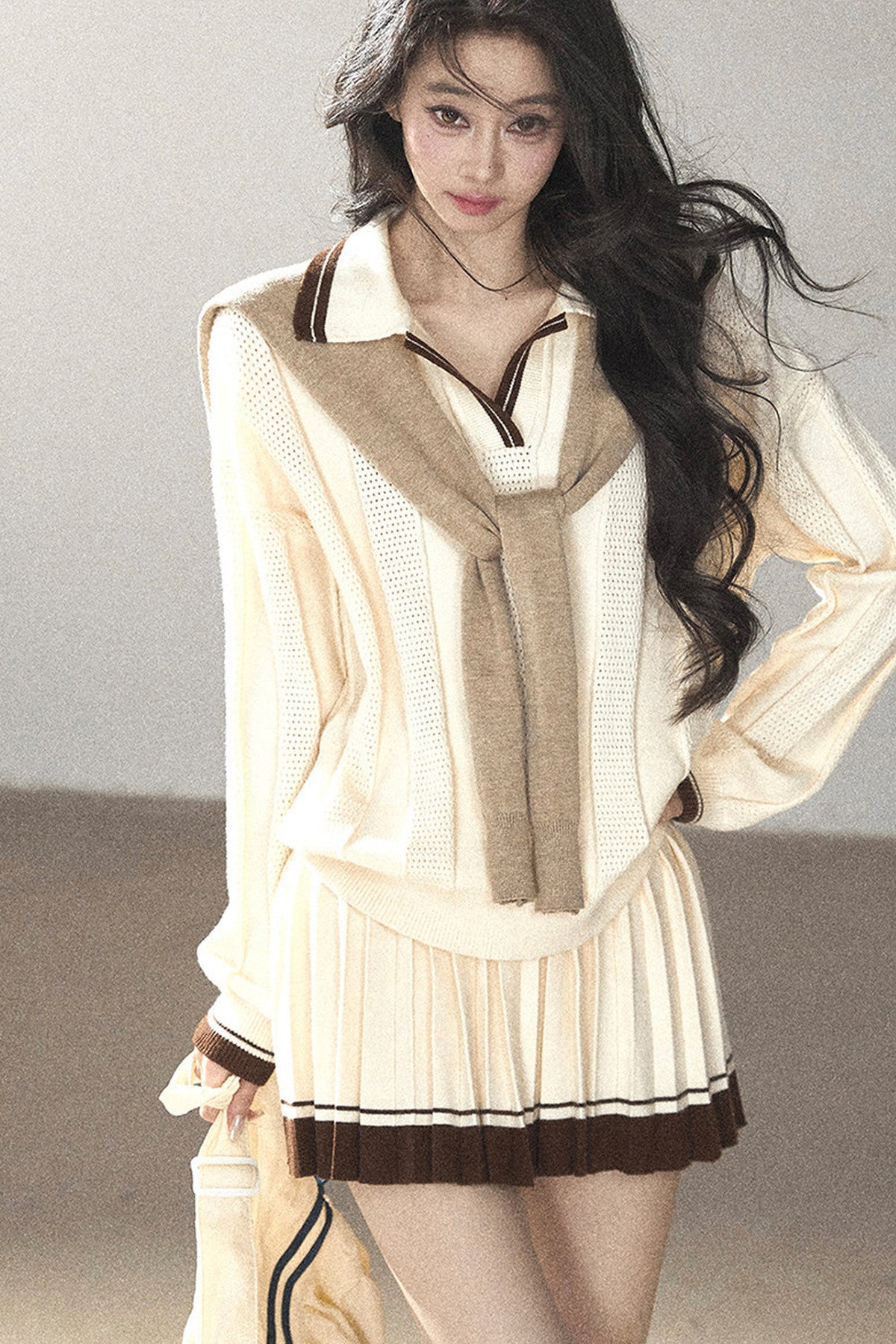 Completo con top a maglia, gonna corta plissettata e giacca